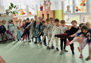 Dzieci ustawione jedno za drugim prezentują swoje piżamowe stroje.