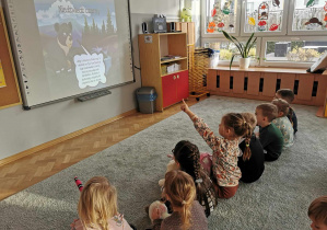 Dzieci oglądają film edukacyjny na temat różnych misiów i niedźwiedzi.