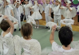 Dzieci prezentują przed publicznością anielski taniec.