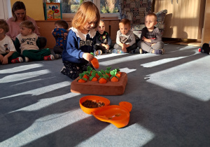 Dziewczynka chowa smakołyki pod marcheweczki.