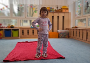 Dziewczynka prezentuje swoją fioletową piżamę.