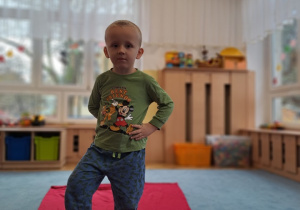 Chłopiec prezentuję piżamę z Mickey i Pluto.