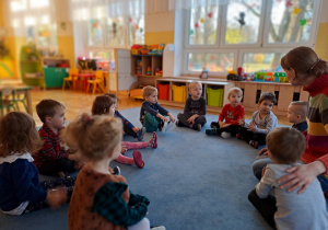 Dzieci siedzą na dywanie i rozmawiają z Ciocią Weroniką o swoich emocjach.