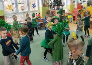 Dzieci wraz z przybyłymi gośćmi- dziećmi z innych grup- tańczą w małych kółeczkach.