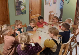 Dzieci po zakończonym spektaklu jedzą słodki poczęstunek.
