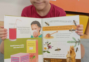 Chłopiec pokazuje książkę o ekologii.