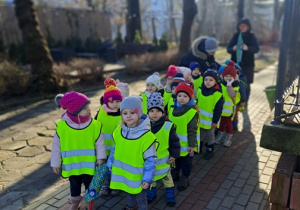Dzieci stoją w parach przed przedszkolem i szykują się na spacer