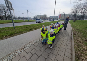 Dzieci trzymają węża z którym chodzą na spacery i zwiedzają Rondo Lotników Lwowskich.