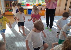 Rozgrzewka dzieci chodzą po dywanie i podnoszą wysoko kolana.