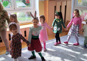 Dzieci trzymają się za ręce i idą po obwodzie koła, śpiewając piosenkę "Maszeruje Wiosna".