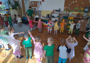Dzieci tańczą do wesołej wiosennej piosenki.