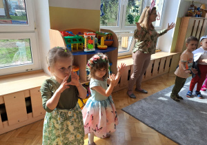 Dziewczynki klaszczą w rytm muzyki.
