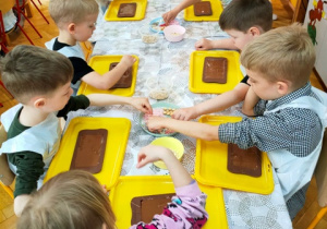 Dzieci dekorują swoje tabliczki czekolady.