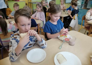 Dzieci jedzą swoje kanapki.
