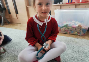 Dziewczynka ogląda stetoskop.