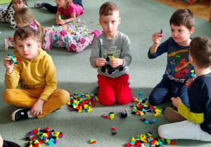 Chłopcy pokazują wytwory swojej zabawy- zbudowane pierwsze konstrukcje.