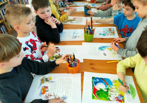 Dzieci rysują wymyślone przez siebie elementy ilustracji.