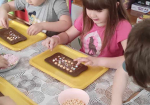 Dziewczynki dekorują czekoladę.