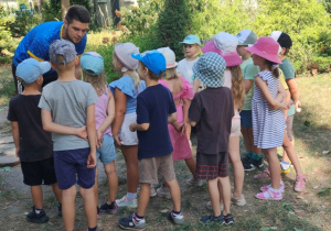 Dzieci stoją przed trenerem- słuchają kolejnego zadania.