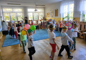 Biedronki i Ważki idą po kole i głośno śpiewają "Hymn przedszkolaka".