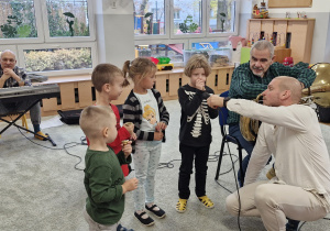 Chętne dzieci próbują wydobyć dźwięk z ustnika tuby.