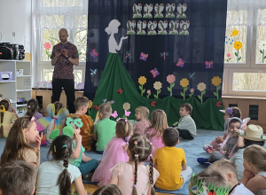 Dekoracja siedzą na dywanie przed wiosenną dekoracją i czekają na rozpoczęcie balu.