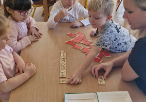 Chętne dzieci grają wspólnie w domino.