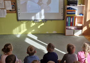 Dzieci oglądają bajkę edukacyjną nt. udzielania pierwszej pomocy.