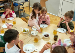 Dziewczynka nabiera powidła śliwkowe z miseczki.