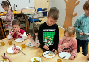 Chłopiec szykuje dla siebie kanapkę z twarożkiem.