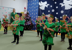 Chłopcy tańczą z cukrowymi laskami do piosenki "Rockin around the christmas tree"."