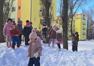 Część dzieci stoi na górce i pozuje do zdjęcia.