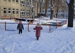 Dziewczynki bawią się na śniegu.