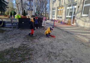 Dzieci biegają po ogrodzie.