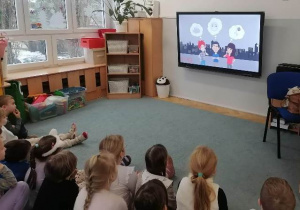 Dzieci oglądają film edukacyjny o różnych źródłach zanieczyszczeń.