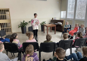 Pani z biblioteki wita się z dziećmi i opowiada o tematyce zajęć.