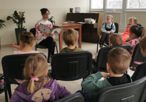 Dzieci słuchają książki pt. "Proszę mnie przytulić".