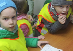 Chłopiec wypisuje pocztówkę i adresuje na przedszkole.