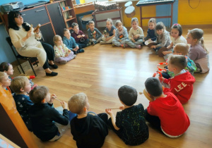 Dzieci siedzą w dużym kole. W rękach trzymają instrumenty na których będą grać w trakcie lekcji muzyki.