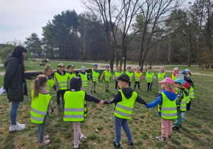 Dzieci stoją w kole i słuchają co będą dzisiaj robić na warsztatach.