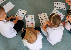 Dzieci wykonują zadanie znajdujące się na karcie pracy.