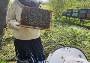 Pani pokazuje dzieciom królową.