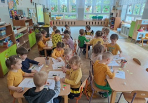 Wspólne zdjęcie dzieci przy stolikach.