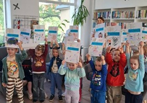 Wspólne zdjęcie dzieci na którym prezentują swoje okładki do książek
