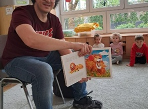 Pan Bartek pokazuje ilustrację w książce.