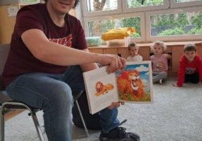 Pan Bartek pokazuje ilustrację w książce.