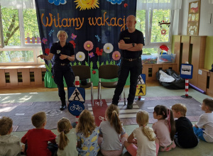 Funkcjonariusze Straży Miejskiej w Łodzi witają się ze wszystkimi dziećmi i rozmawiają na temat bezpieczeństwa na drodze.