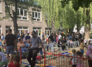 Cała społeczność przedszkola bawi się na rodzinnym pikniku w ogrodzie.
