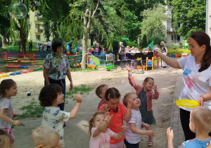 Dzieci łapią bańki mydlane.