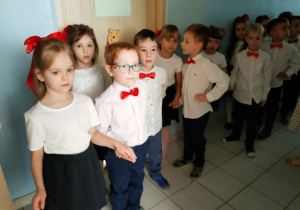 Grupa ustawiona w pary na korytarzu, szykuje się do wejścia do klasy przy dźwiękach poloneza.